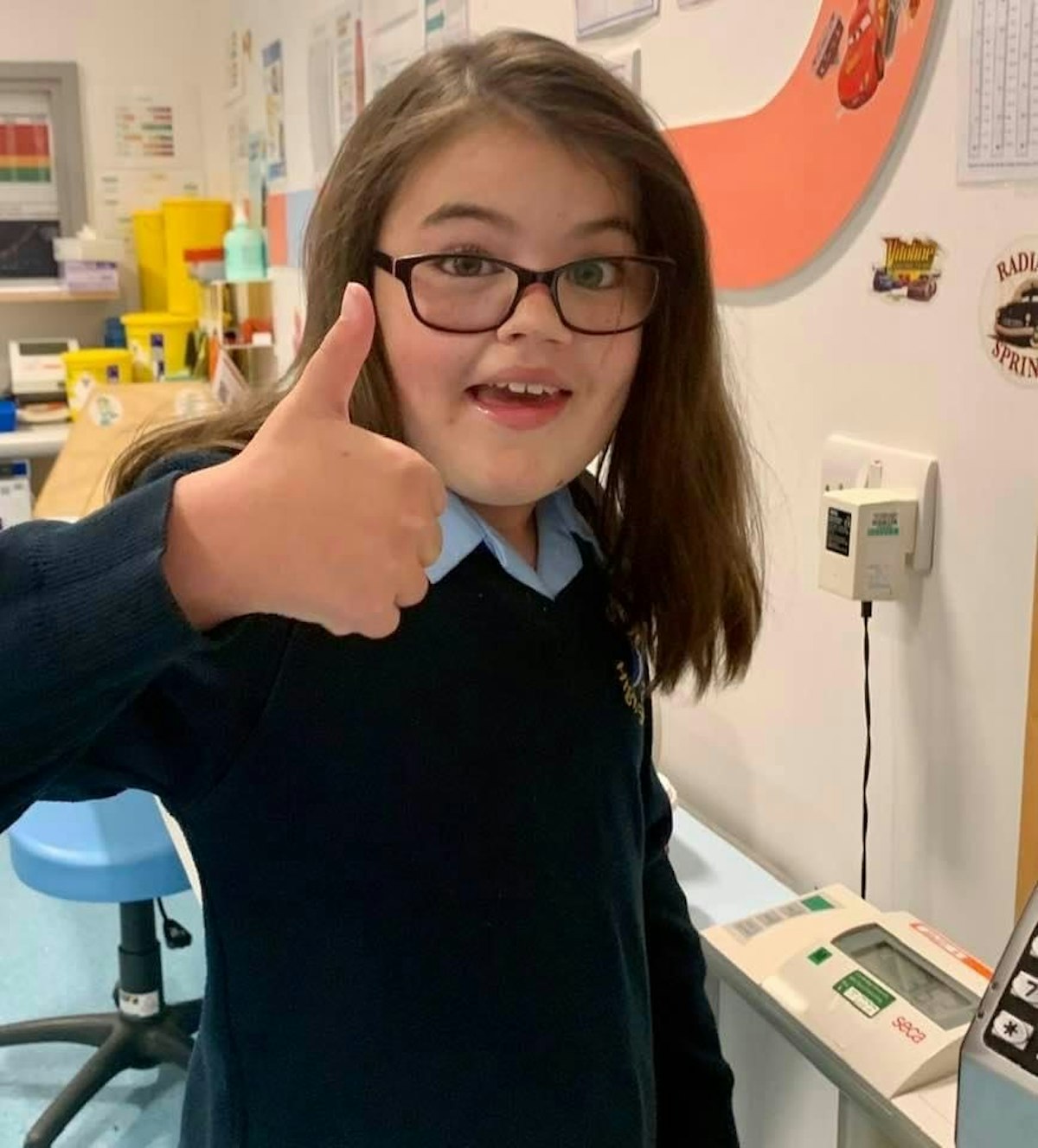 Camille giving a thumbs-up during a hospital visit.